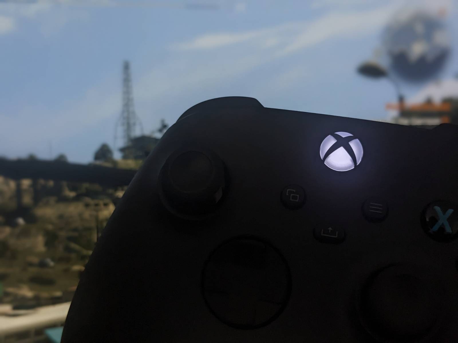 Image shows the controller. There&rsquo;s a game in the background